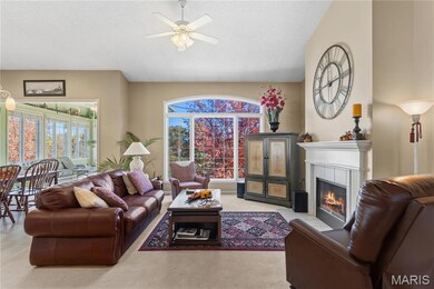 Living room featuring a fireplace, ceiling fan, and carpet flooring