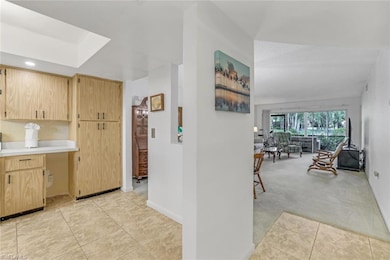 Kitchen with light brown cabinetry and light carpe