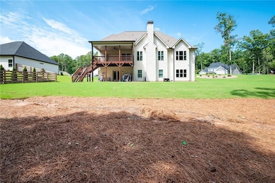 Back of property featuring ceiling fan, a yard, an