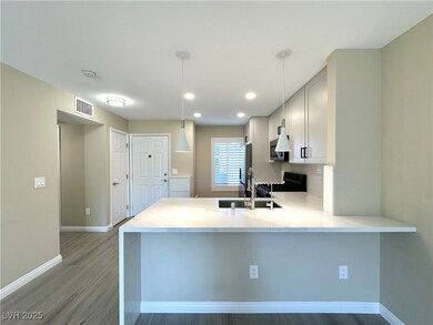 Kitchen with gas stove, a peninsula, light wood-ty