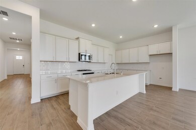 Kitchen featuring white cabinets, backsplash, sink