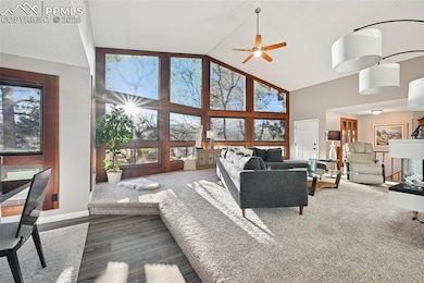 Living room with high vaulted ceiling, healthy amount of natural light, luxury vinyl floors and ceiling fan
