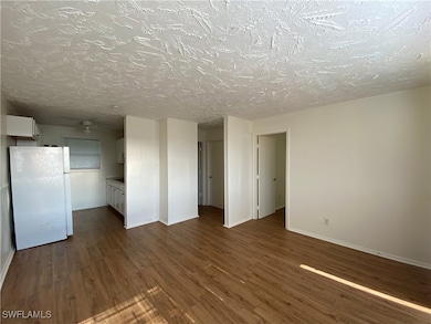 Unfurnished living room with dark wood-style floor