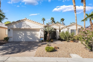 Mediterranean / spanish-style home with an attached garage, driveway, stucco siding, and a tiled roof