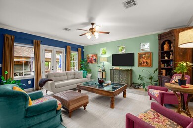 Living room with a ceiling fan, ornamental moldin