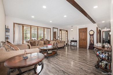 Living area featuring wood finished floors, recessed lighting, and beam ceiling