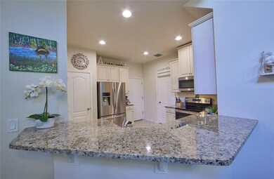 Great view of the bar in the kitchen eating space. The granite counters are so rich make this kitchen sparkle! There is plenty of room for bar stools.