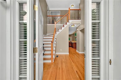 Foyer with light wood finished floors, baseboards, stairs, plenty of natural light