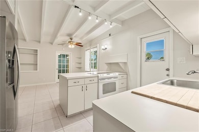 Kitchen with beamed ceiling, a peninsula, a sink, 