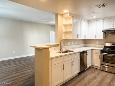 Kitchen featuring open shelves, and light stone countertops