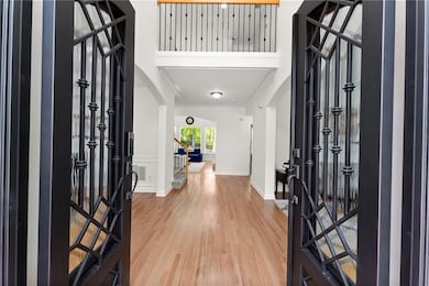 Foyer with arched walkways, crown molding, and lig