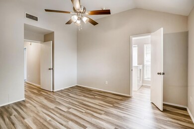 Unfurnished bedroom with lofted ceiling, light wood-style floors, and a ceiling fan