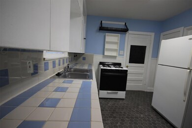 Kitchen with freestanding refrigerator, range wit