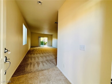 Corridor with light colored carpet and light tile patterned floors