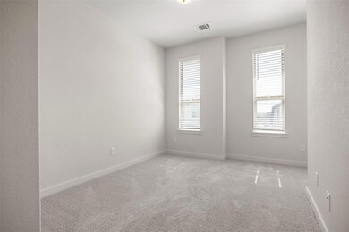 Unfurnished room with light colored carpet and ba