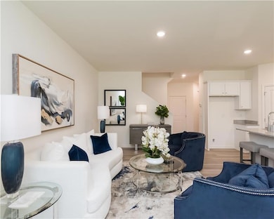Living area with recessed lighting and light wood-style flooring