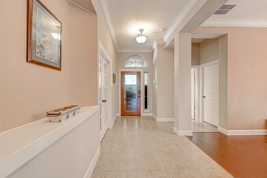 A grand entry with an office on the left and a bedroom and full bath on the right.