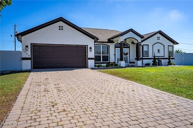 Ranch-style house featuring decorative driveway, stucco siding, and an attached garage