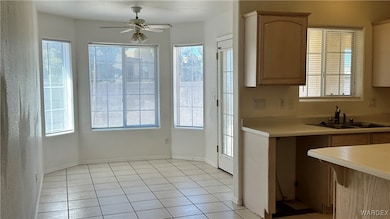 Kitchen featuring a ceiling fan, baseboards, light