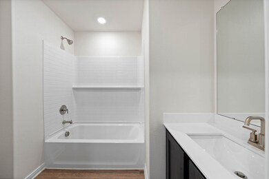 Bathroom with shower / tub combination, vanity, and dark wood-style floors