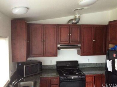 KITCHEN WITH WALNUT CABINETS AND BLACK APPLIANCES.