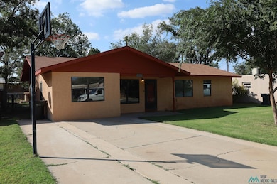 View of front facade with a front lawn, stucco siding, and a patio area