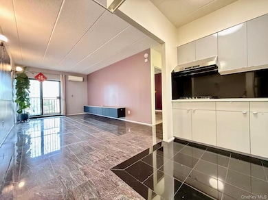 Kitchen featuring white cabinetry, a textured ceiling, open floor plan, modern cabinets, and a wall mounted air conditioner