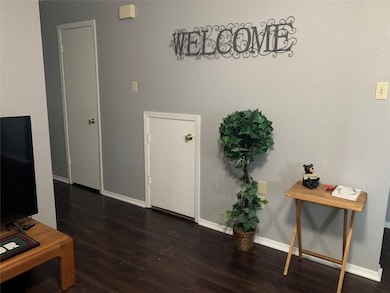 Living room with dark wood-style floors and baseboards