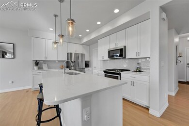 Kitchen featuring white cabinetry, stainless steel