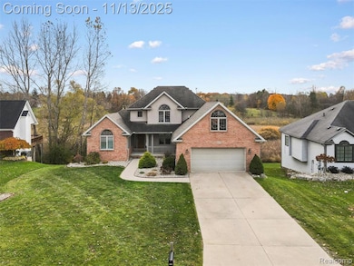 Traditional home featuring covered porch, brick siding, a front yard, and concrete driveway