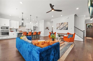 Living area with recessed lighting, ceiling fan, dark wood finished floors, stairs, and ornamental molding