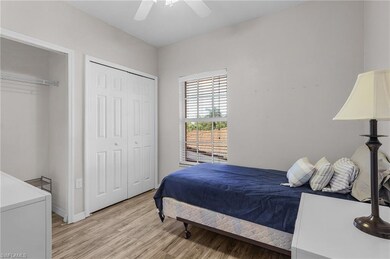 Bedroom with light wood finished floors, a ceiling fan, and two closets