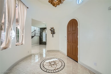 Foyer entrance with arched walkways, a towering ce