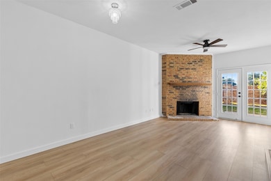 Unfurnished living room featuring a fireplace, light wood finished floors, and ceiling fan