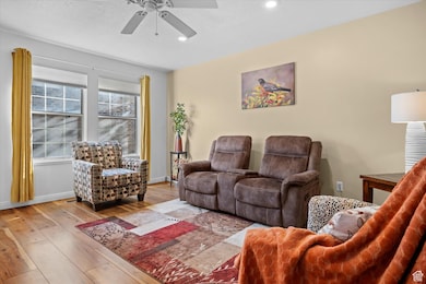 Living area with hardwood / wood-style flooring, recessed lighting, a ceiling fan, and a textured ceiling