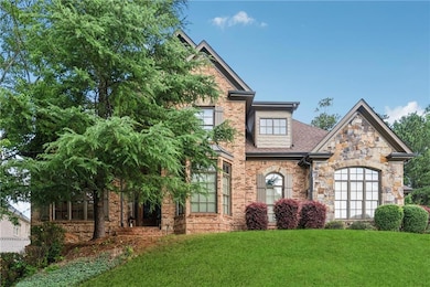 Craftsman inspired home with a front lawn, a shingled roof, stone siding, and brick siding