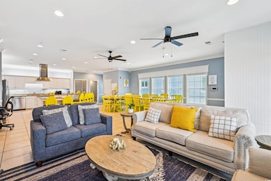 Living room featuring light tile patterned floors, crown molding, recessed lighting, and ceiling fan