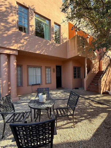 Back of property with stucco siding, stairs, and a patio