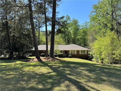 Ranch-style home with brick siding, a view of tree