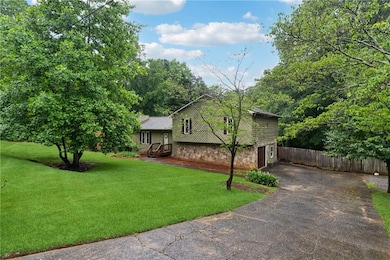 View of front of property with stone siding, driveway, and an attached garage