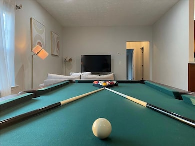 Playroom with a textured ceiling and pool table