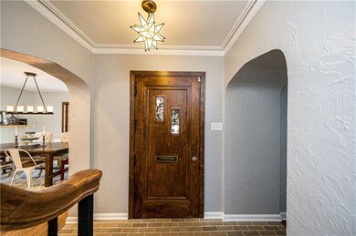 Impressive wood door opens into brick-floored entr