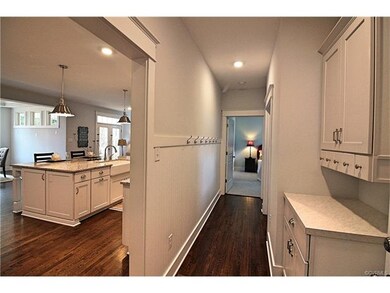 Back hallway off the garage includes a custom drop zone, walk in pantry, and full guest suite and full bath.