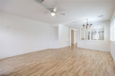 Spare room featuring a chandelier, light wood fini