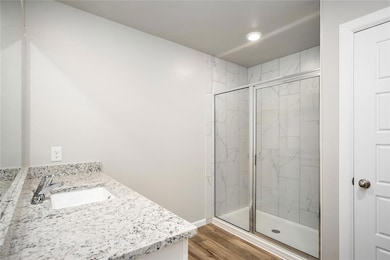 Spa-inspired ensuite featuring a granite vanity and oversized walk-in shower with tile surround.