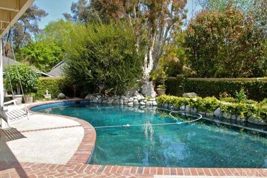 Lush landscape surrounds the inviting pool and spa