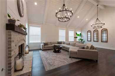 Living room with a brick fireplace, dark hardwood