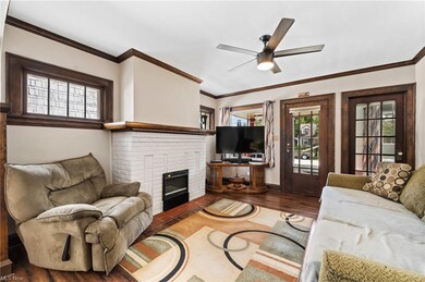 crown molding, a fireplace, and ceiling fan