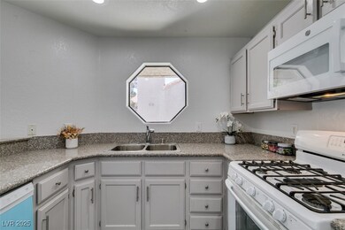 Kitchen with white appliances and a sink