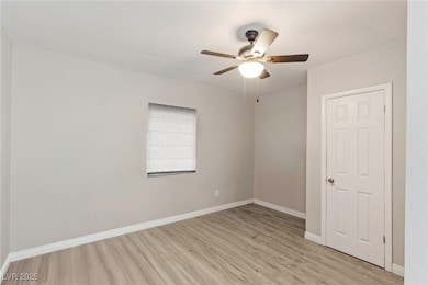 Empty room with light wood finished floors and a ceiling fan